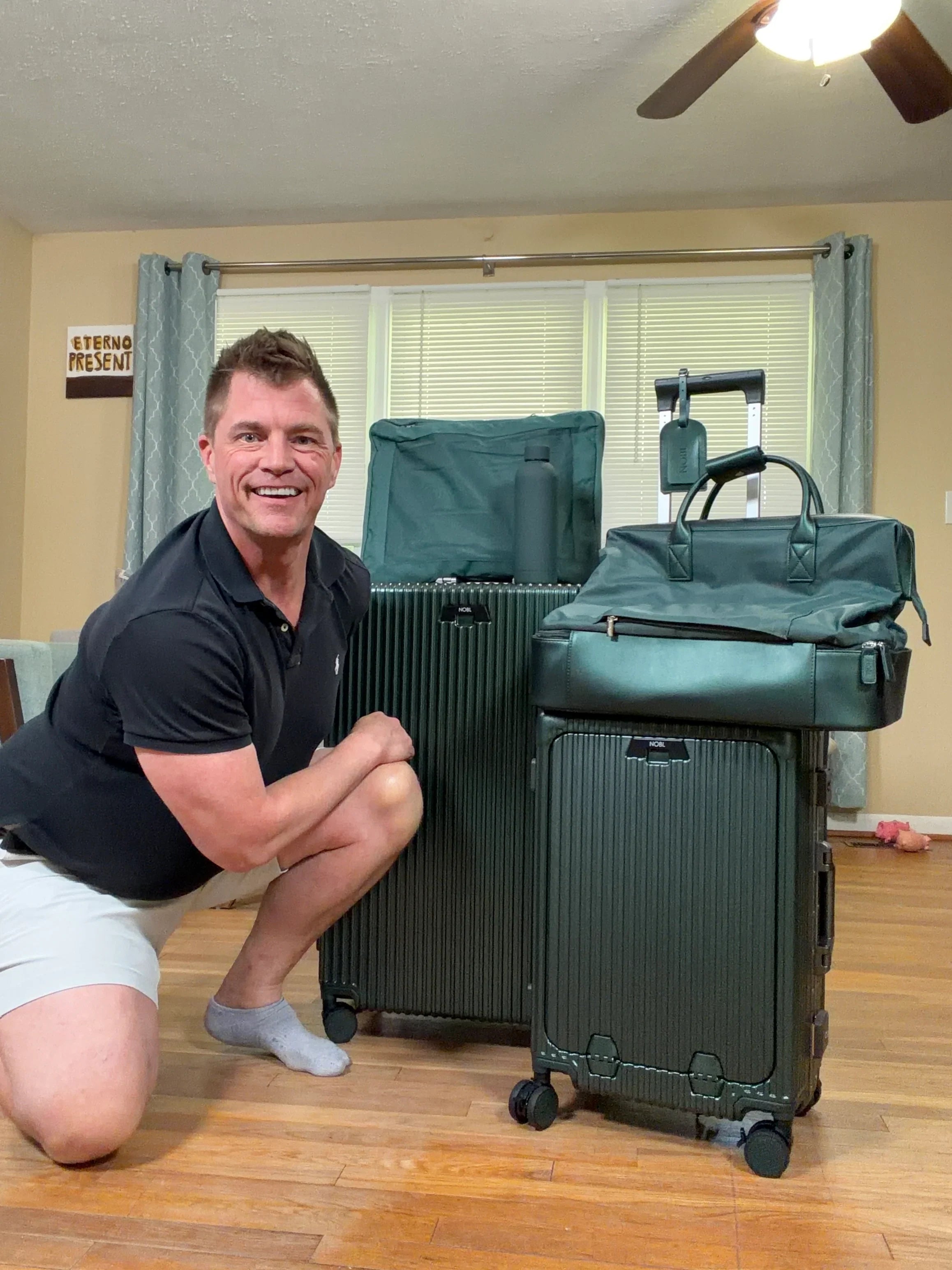 Smiling traveler with green luggage